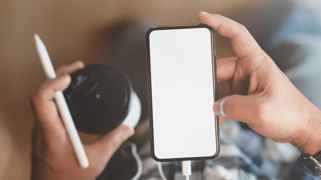 a person holding a smartphone with a white blank screen