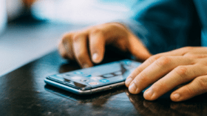 a person using a cell phone on a table