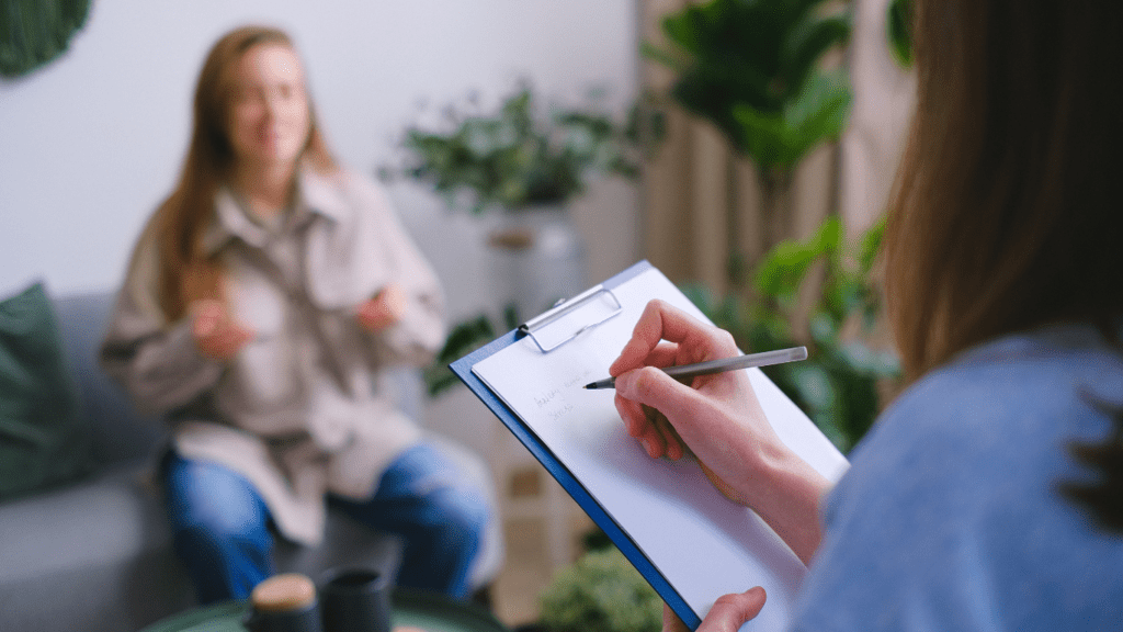 a person sitting on a couch with a pen and paper in front of them