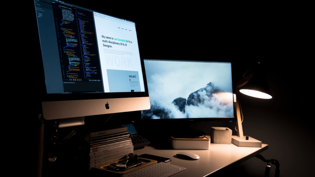 a desk with an apple computer and a plant on it