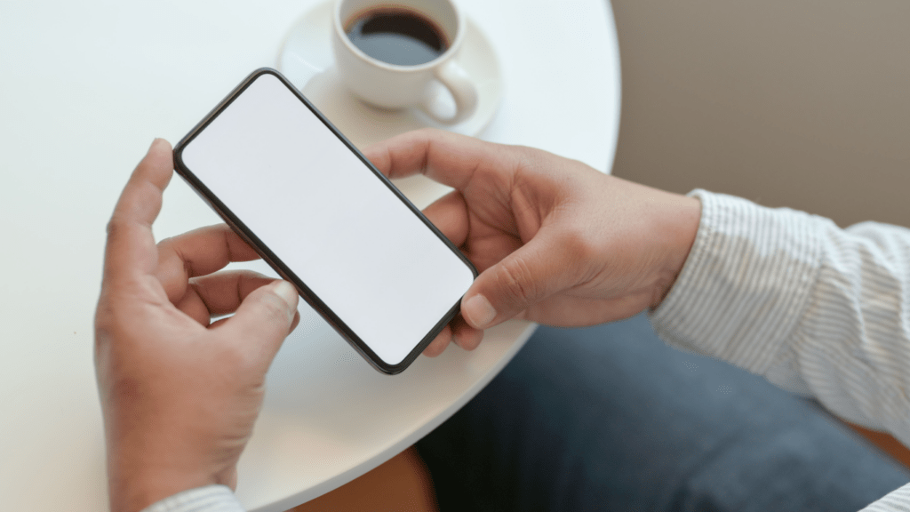 a person holding a smartphone with a white blank screen