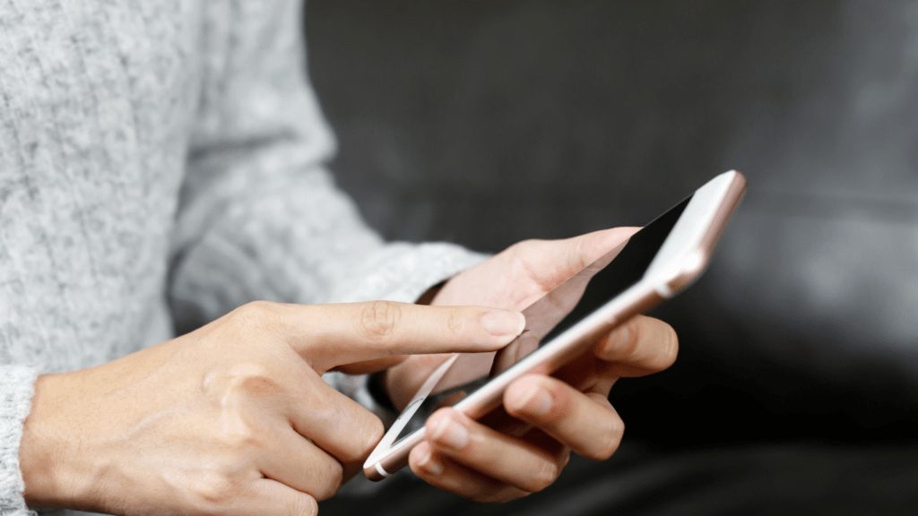 a person is using a cell phone while sitting on a couch