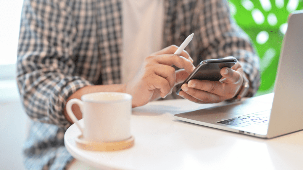 a person using a cell phone on a table