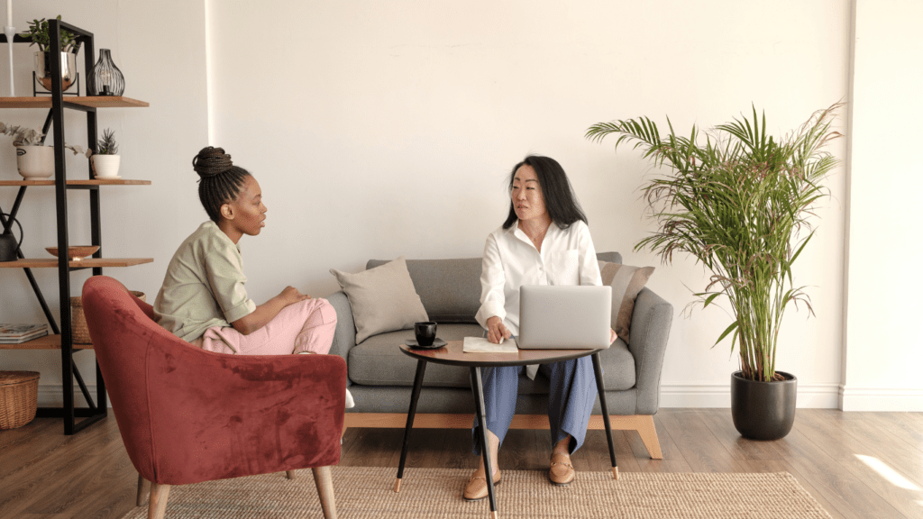 two people sitting on a couch talking to each other