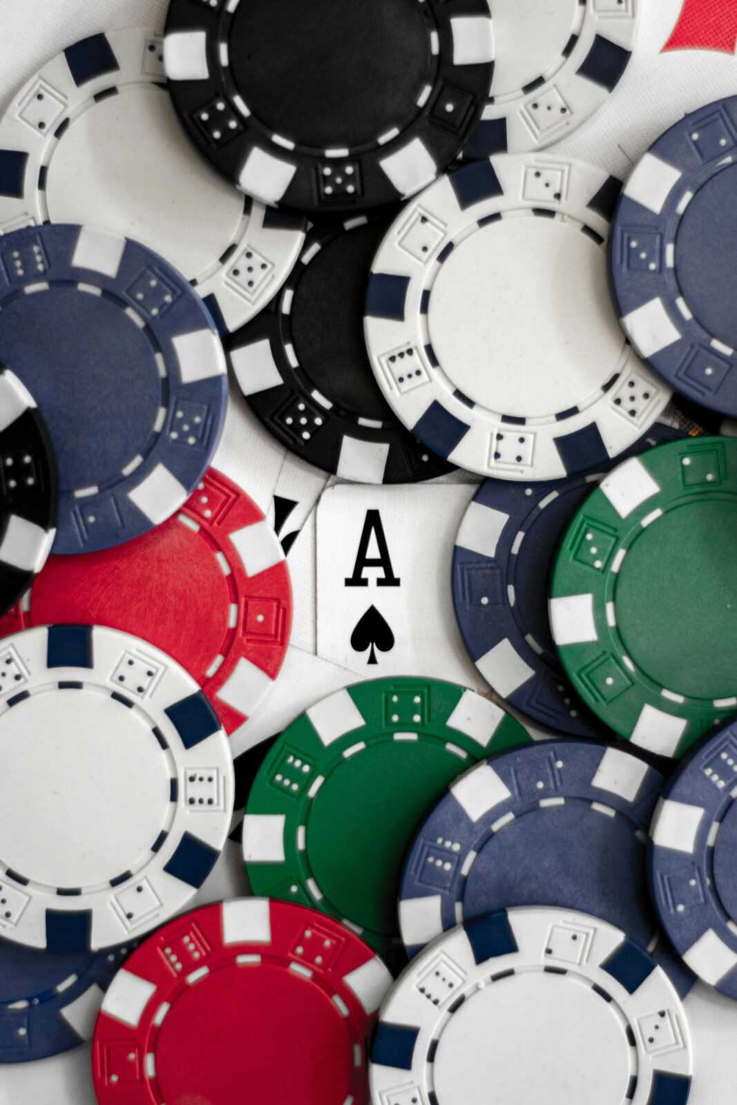 Close-up of poker chips with an ace of spades card, perfect for casino themes.